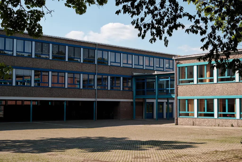 Middelbare school met lange rijen ramen rond een plein