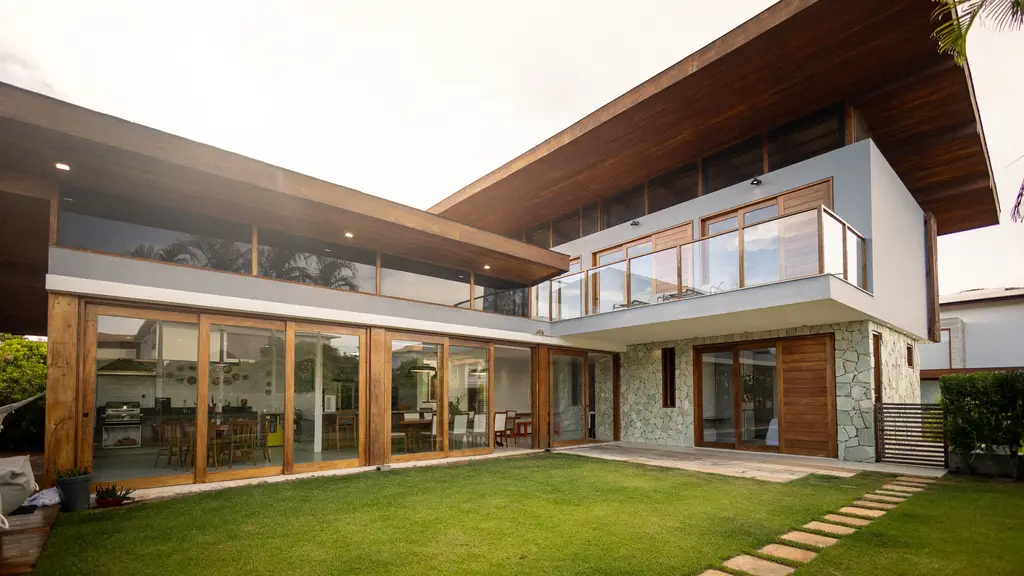 Moderne woning met grote glazen puien, houten details en een gazon